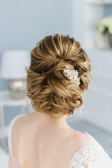 Bride sitting back on the bed, the morning of the bride, wedding hairstyle