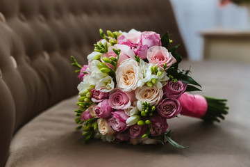 The bridal bouquet lies on the surface and consists of lilies, roses, peonies, lumpy roses, peony roses
