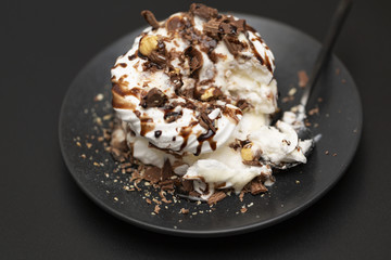 Meringue dessert with chocolate sauce, chocolate, nuts and cream.