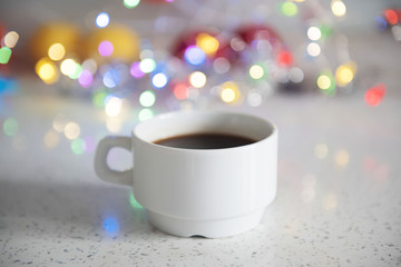 White cup with tasty Christmas coffee. Glowing background.