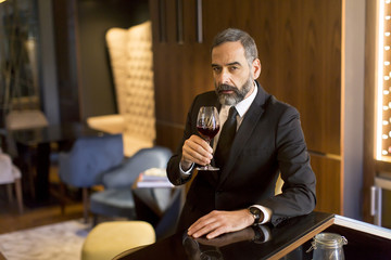 Senior handsome man drinking red wine