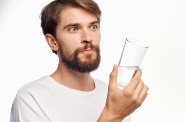 bearded man holding a glass of water in front of him