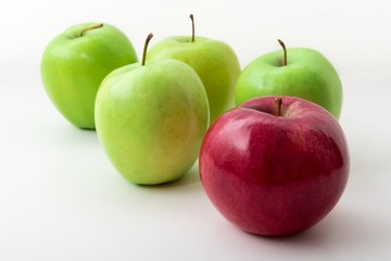Five apples on white separeted background. One apple is red in front and four apples are green in behind.