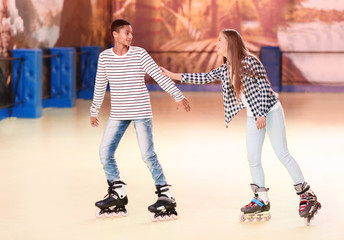 Cute teenage couple at roller skating rink © Africa Studio