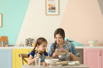 Obraz na płótnie Canvas Mother and daughter preparing dough indoors