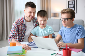 Children with father doing homework at home