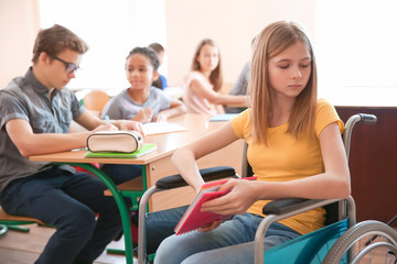 Sad teenage girl in wheelchair at school © Africa Studio