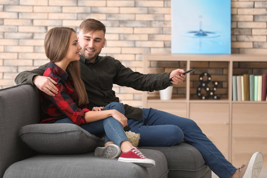 Young couple watching TV at home