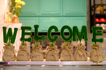 Green welcome alphabet on the small rattan bags for decoration