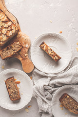 Homemade vegan banana bread with almonds and chocolate, gray background, top view