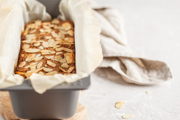 Homemade vegan banana bread with almonds and chocolate, white background, copy space.