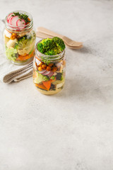 Healthy Homemade Mason Jar Salad with baked vegetables, hummus, tofu and chickpeas, copy space.
