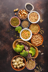 Vegan protein source. Tofu, beans, chickpeas, nuts and seeds on a dark background, top view, copy space.