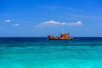 Orange ferry ship in azure sea, Loh Moo Dee Beach, Phi Phi Don,
