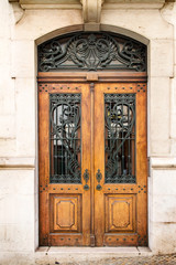 Vintage wooden door with metal lattice built in stone house.