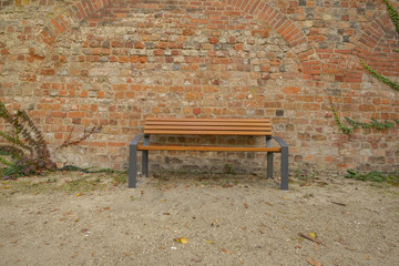 Bank vor einer Backsteinmauer
