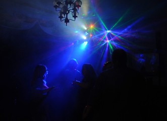 Tanzende Menschen in einer Disco in buntem Licht