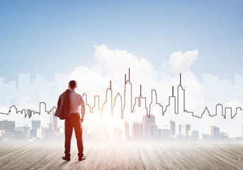 Motivation and inspiration concept with modern cityscape and businessman observing it