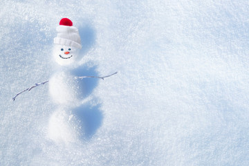 Cheerful snowman of snowdrifts on snow  outdoors on nature in sunny day with copy space, flat lay....
