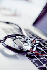 Stethoscope in close-up over laptop keyboard