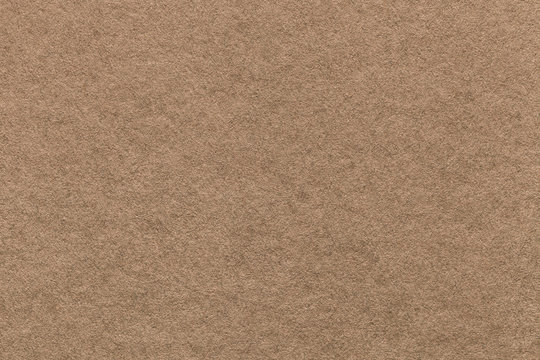 Texture of old light brown paper background, closeup. Structure of dense cardboard