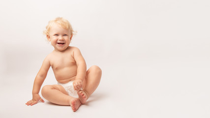 Infant child baby girl in diaper laughs happy looking at the camera isolated on a white background