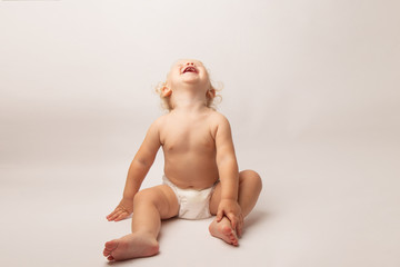 Infant child baby girl in diaper laughs happy looking at the camera isolated on a white background