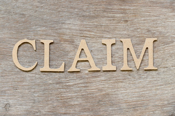 Alphabet letter in word claim on wood background