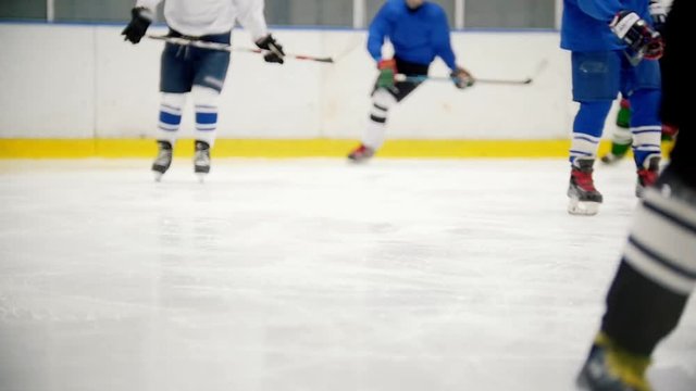 Hockey players quickly run on the ice during training. View without faces