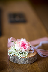 background for the autumn wedding invitation, two wedding rings on a piece of wood decorated with rose flower and ribbons, place for text