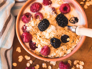 Smoothie yogurt bowl with oats and berries on wooden rustic board. Healthy eating breakfast
