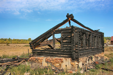 Burnt and charred log house in the remote Russian village