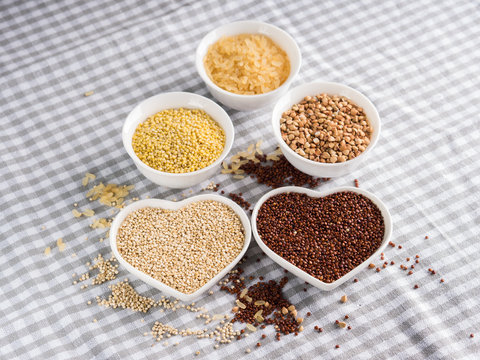 Gluten free grains quinoa, rice, buckwheat, amaranth, millet in bowls on kitchen table. Celiac diet