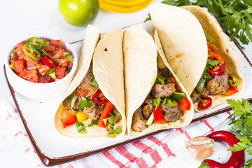 Mexican pork tacos with vegetables and salsa.