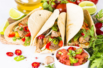 Mexican pork tacos with vegetables and salsa.