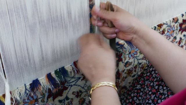 Unidentified woman weaves Turkish carpet in Turkey.