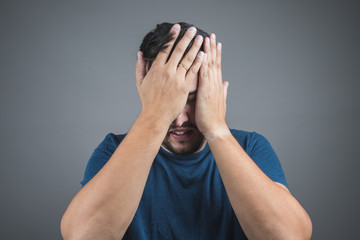 man with headache, putting his hands on his face