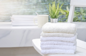 Obraz na płótnie Canvas White towels on white beach chair with copy space on blurred blue sea background