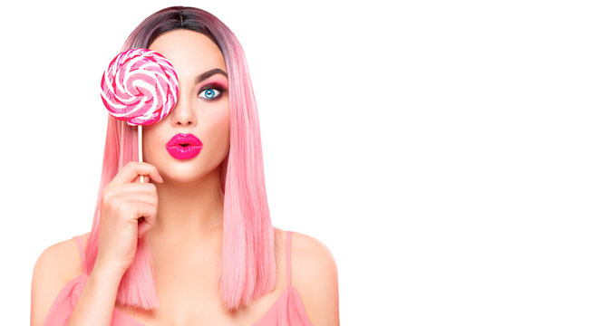 Beauty sexy model woman with trendy pink hairstyle and beautiful makeup holding lollipop candy isolated on white background