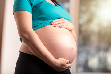 Pregnant woman with hands on her belly