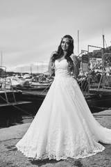 Brunette bride in a long white dress near the sea