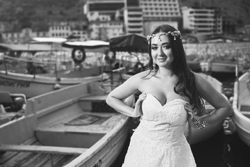Naklejka premium Brunette bride in a long white dress near the sea