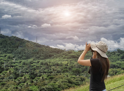 Woman traveler take photo view of green mountain with her camera on holiday