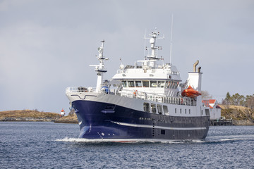 Fototapeta na wymiar Fishing boat Runing M-121-A on a way through Bronnoysund Northern Norway
