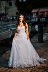 Naklejka premium Brunette bride in a long white dress near the sea