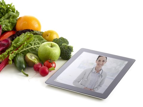 Fruit and vegetables with doctor on digital tablet