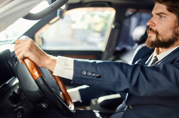 business man in a blue suit driving a car