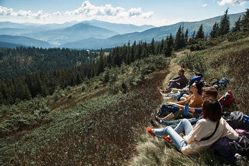 Fototapeta premium Pano shot of a beautiful Carpathian scenery with a group of travelers resting on the hills