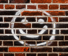 Smiley Graffito auf einer Backteinmauer