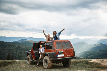 Upbeat young travelers enjoying their expedition in the Carpathian mountains and resting together during their weekend - obrazy, fototapety, plakaty
